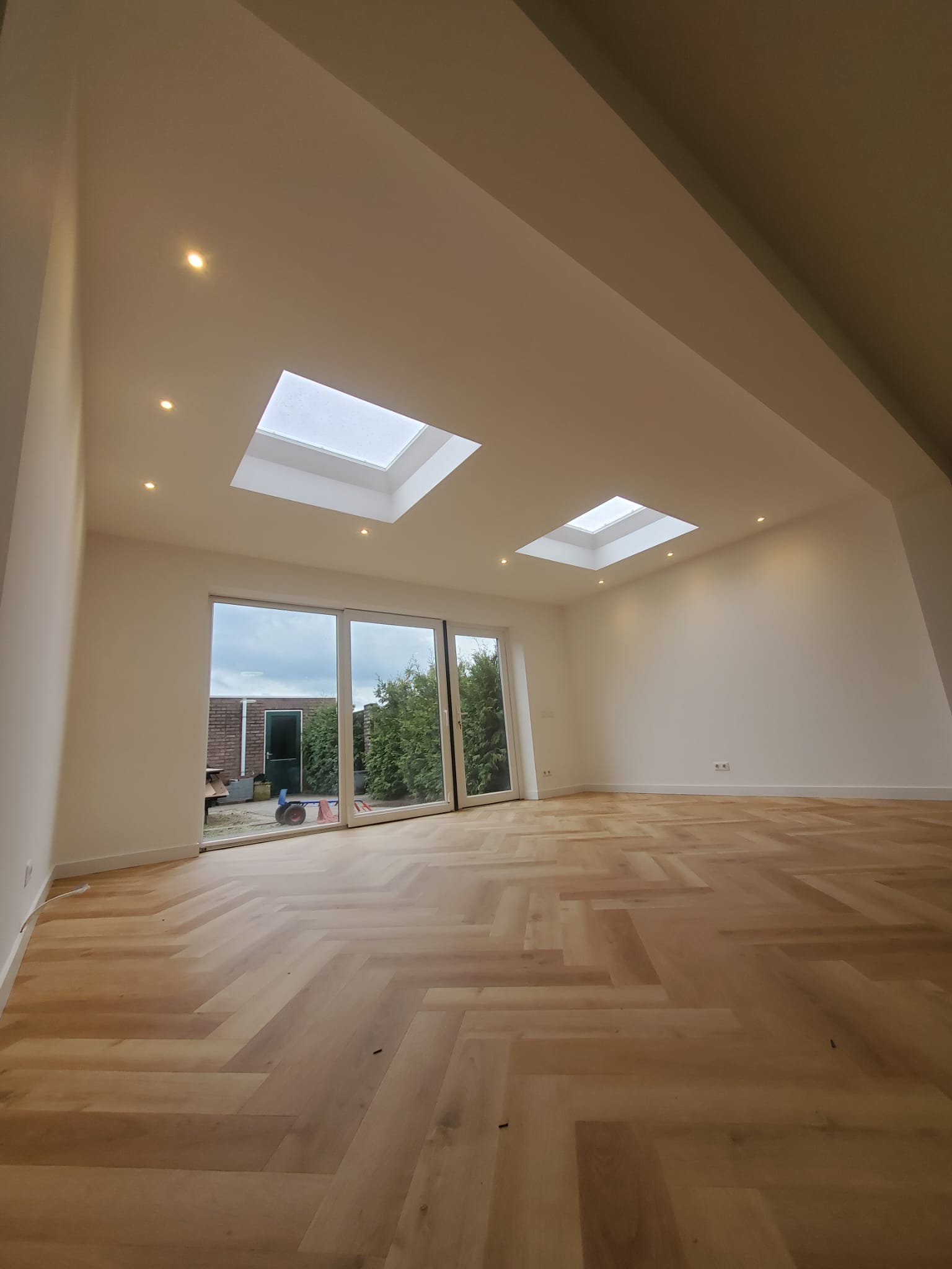 Lege ruimte na dakkapel met visgraatvloer en lichtkoepels